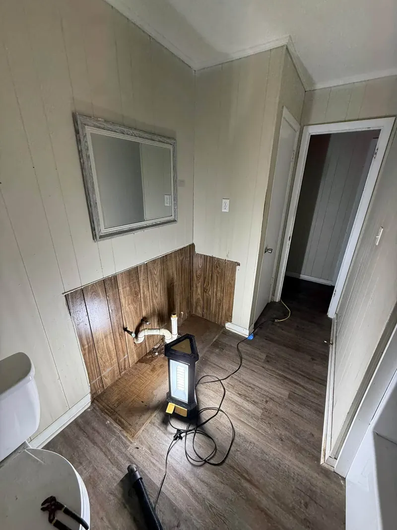 Hallway with wood wainscoting, new wood-look flooring and a work light