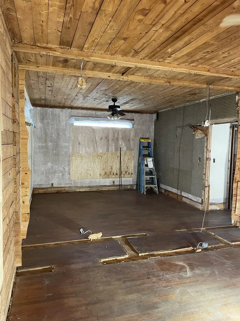 Wood-paneled room with plank ceiling, ceiling fan and a window on the far wall