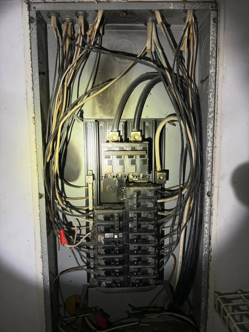 Open electrical panel with breakers and wiring