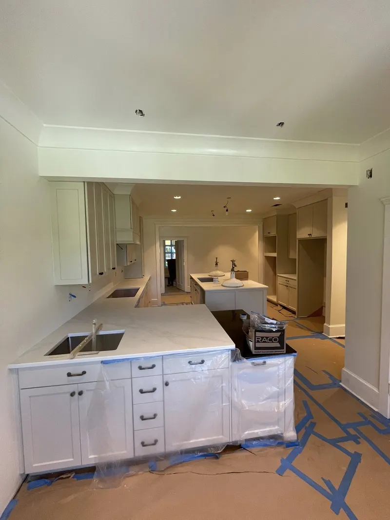 White kitchen with island, quartz-look counters and long runs of cabinets