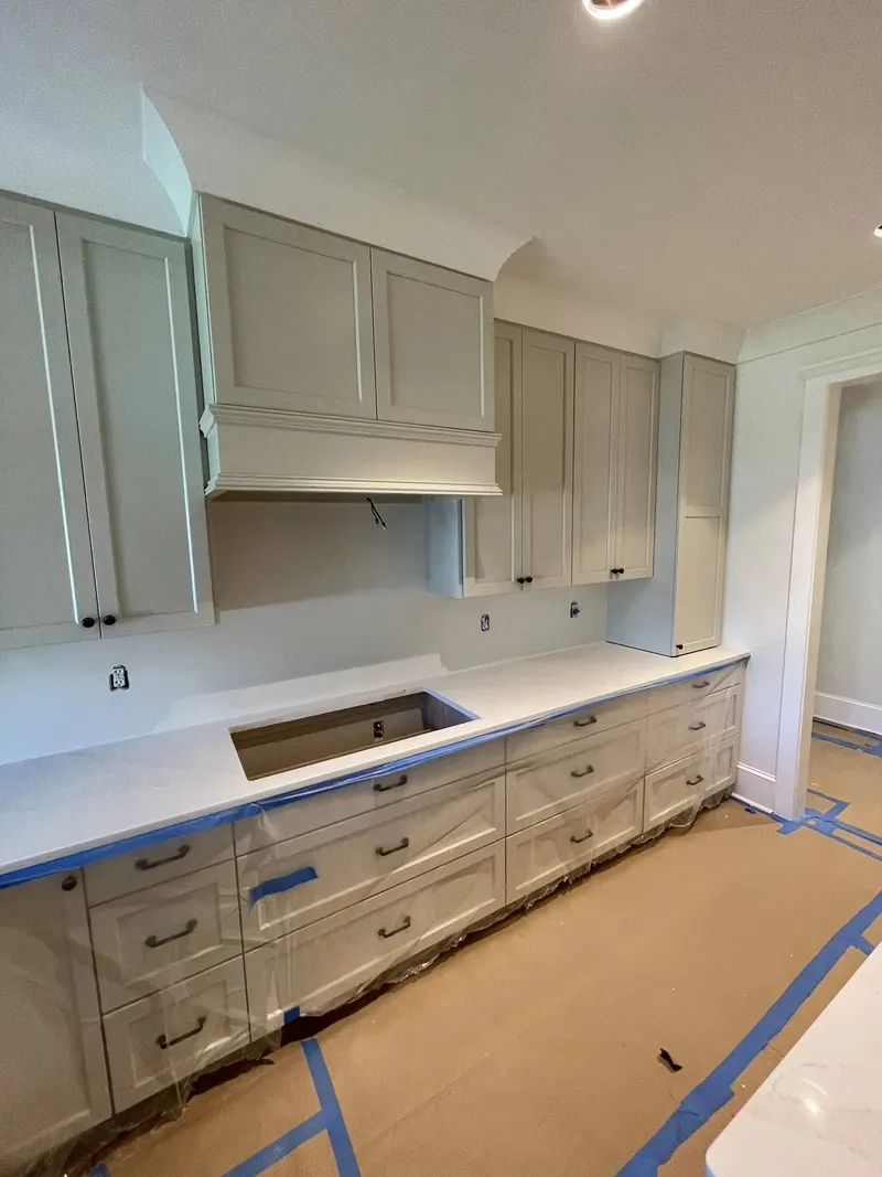 White kitchen cabinets with crown molding and light countertops