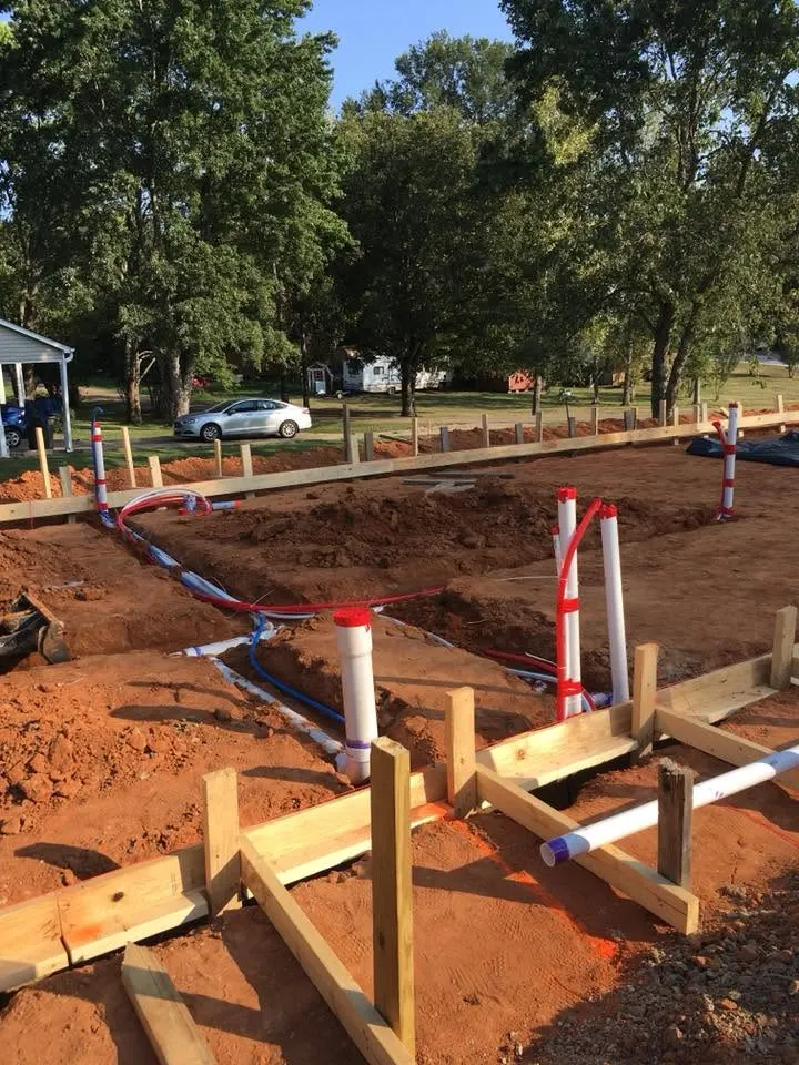 Rough plumbing pipes and stub-ups set in forms before the slab is poured