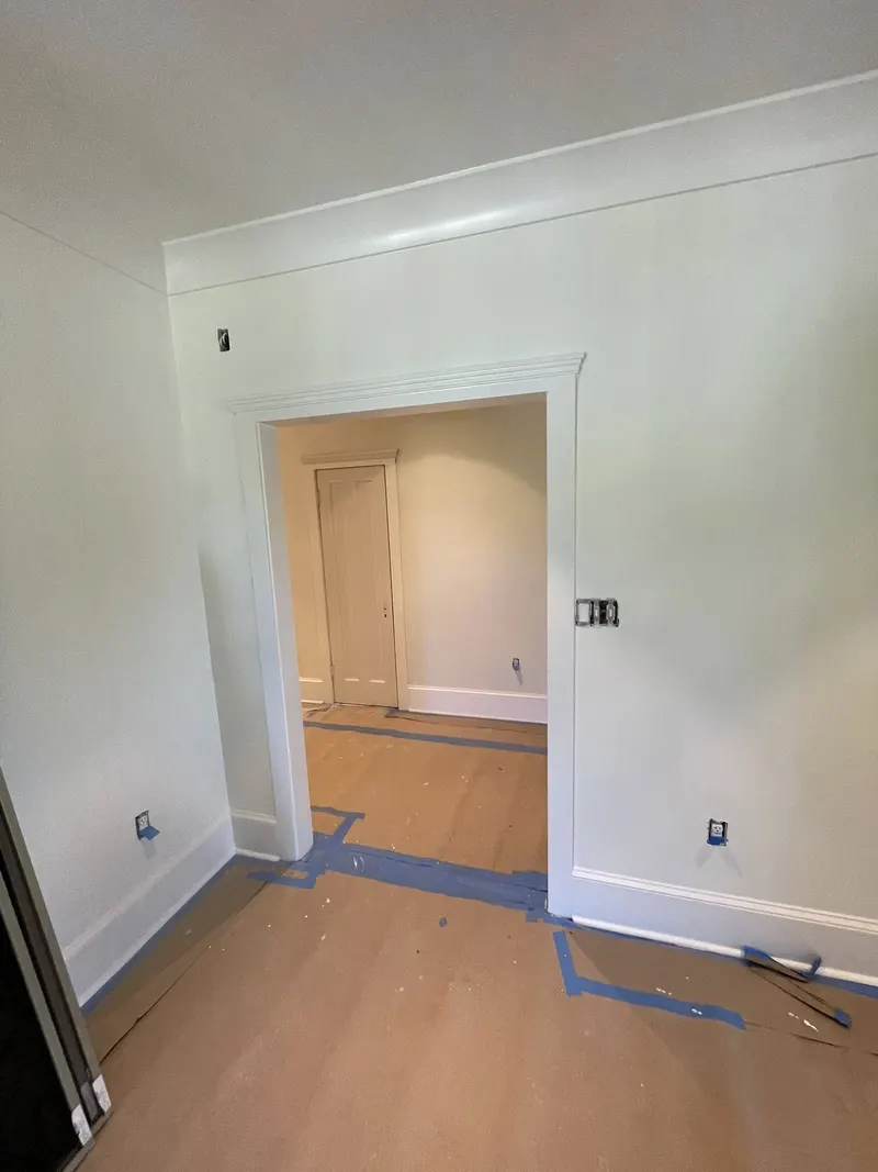Painted room with cased doorway, baseboards and crown molding