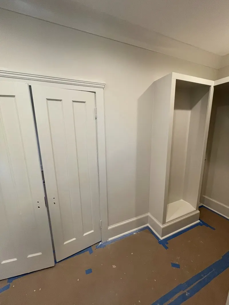 Paneled double closet doors and built-in cabinet with painted trim