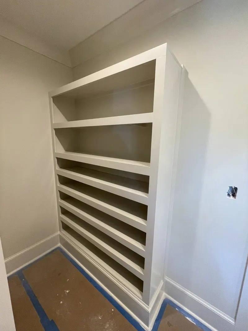 Built-in shelving with painted trim in a white room