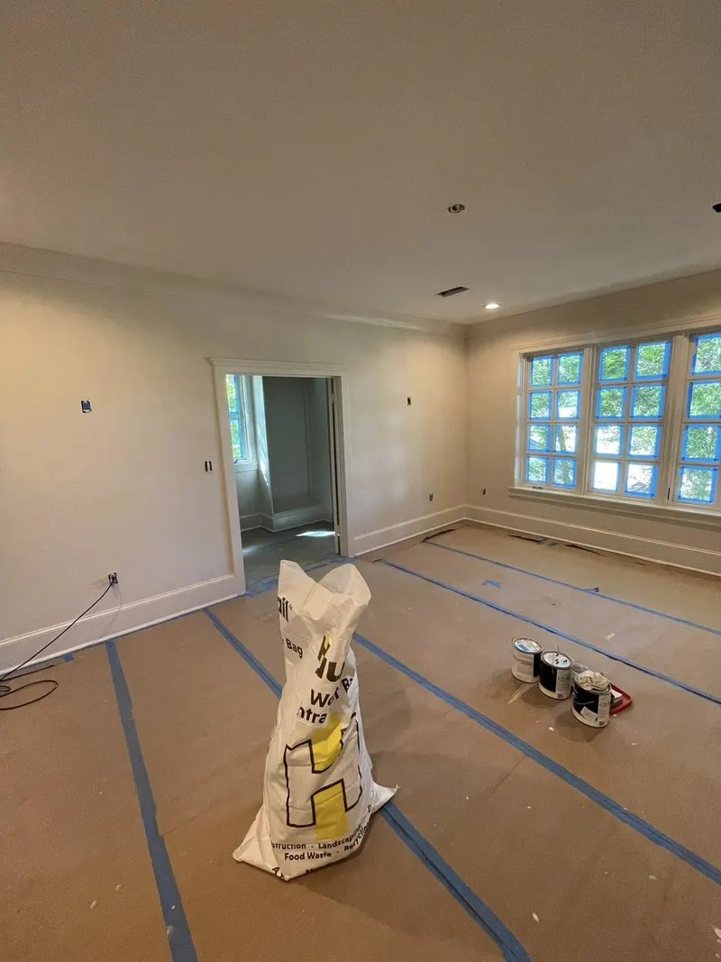 Large room with windows, crown molding and protected floors
